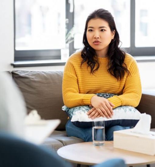 A woman talks with a therapist at a drug and alcohol rehab facility