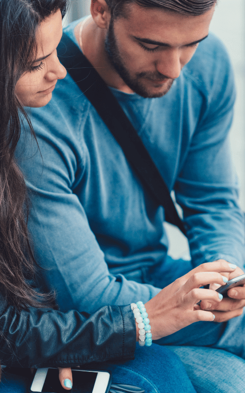 A young couple using a mobile phone to check insurance coverage for couples rehab