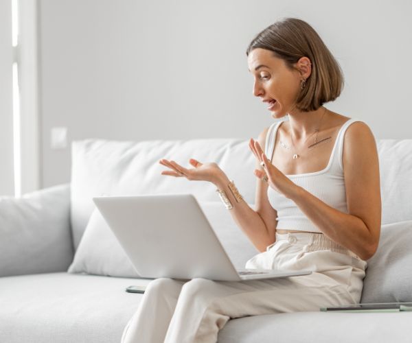 A woman using her laptop for an online addiction rehab session