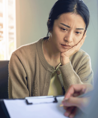 Young woman her head on one hand during a PHP rehab assessment