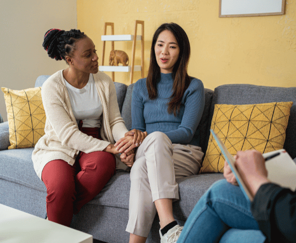 Two women meet with a therapist about couples addiction rehab treatment programs