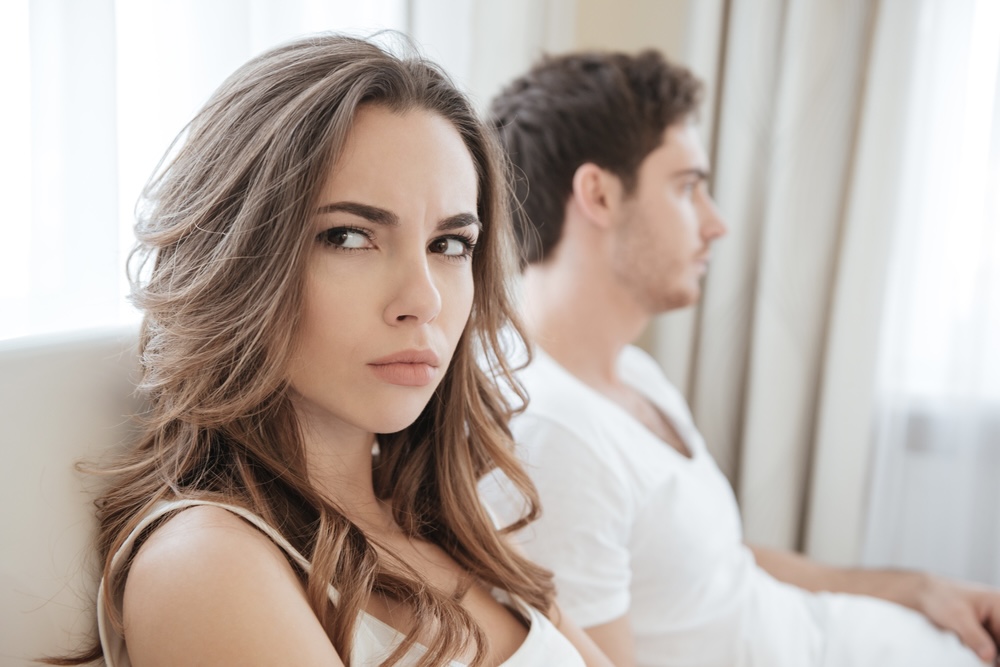 Female on the couch considering if she should get back with an ex after rehab