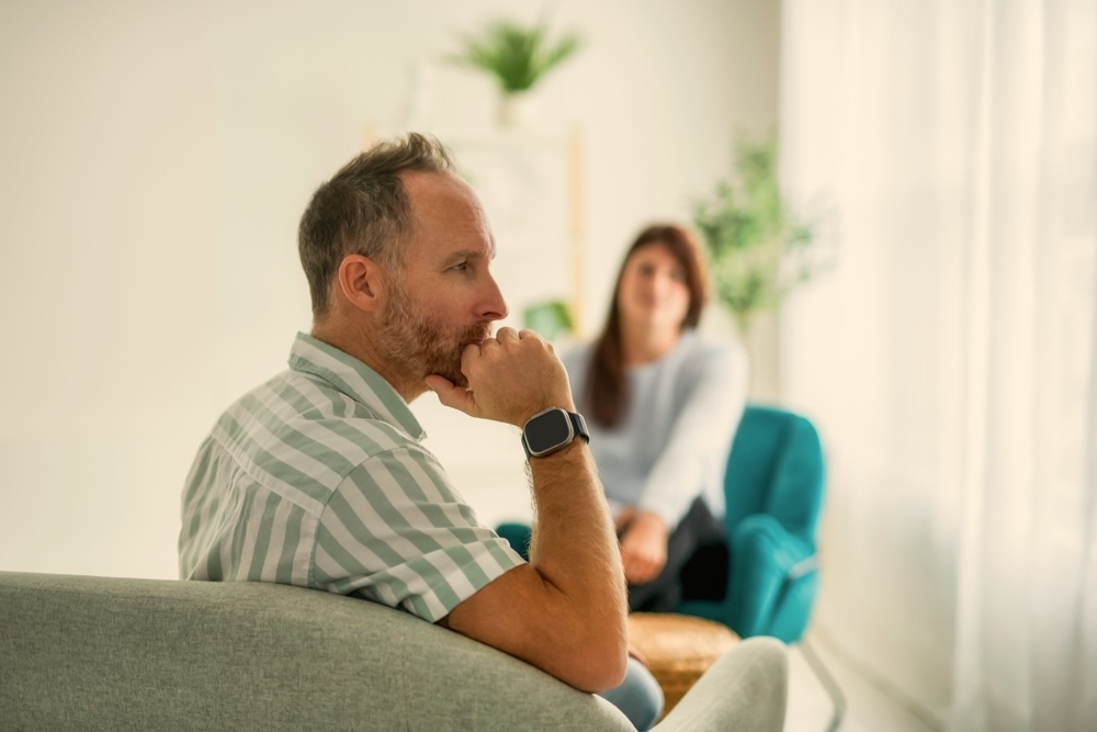 Male adult wondering how long is alcohol rehab talking to an addiction specialist