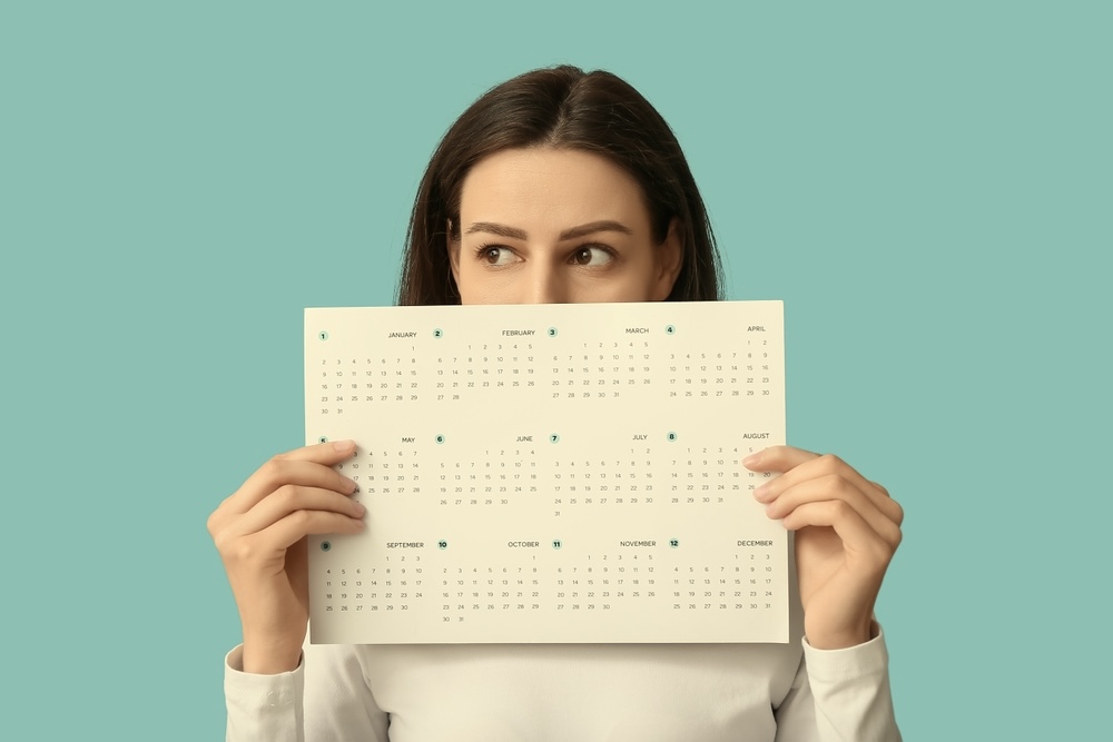 Female holding a calendar thinking how long is alcohol rehab