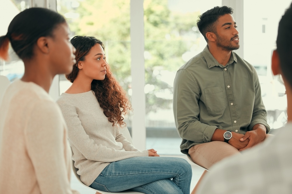 Adults listening to an addiction treatment group therapy
